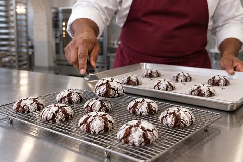 Chocolate crinkle cookies cooling on a wire rack.